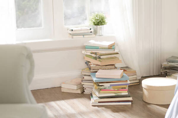 Stack of books in a calm indoor reading space with warm natural light